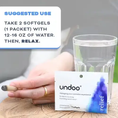 1 pack of undoo relief gels on wooden table next to a glass of water and a woman with a cannabis joint in her hand.